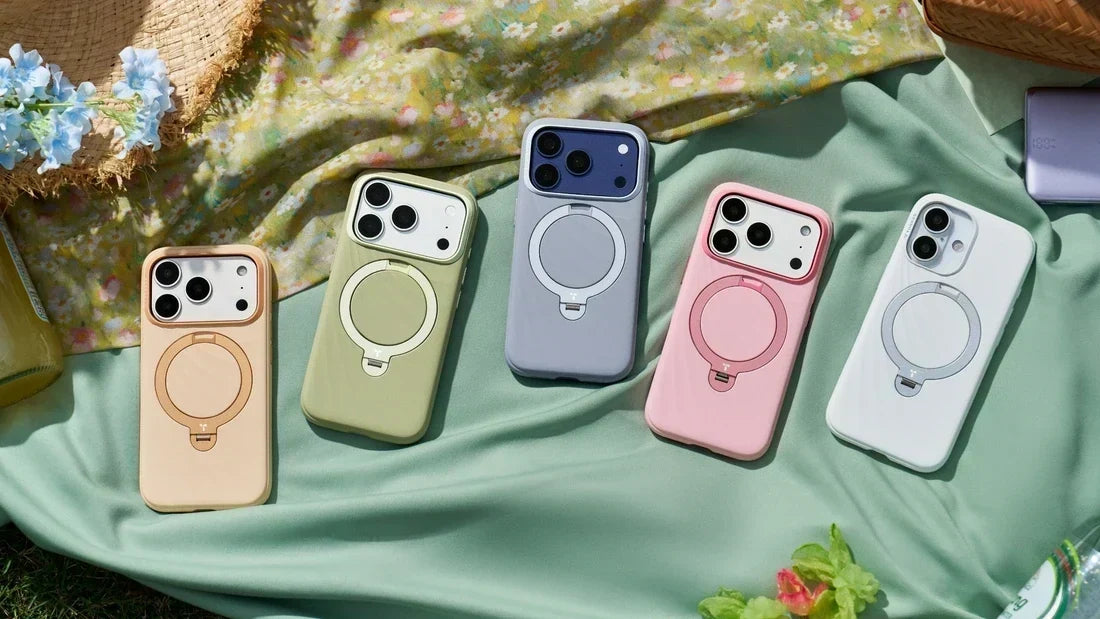Five smartphones in colorful protective cases with circular magnetic rings displayed on a picnic blanket
