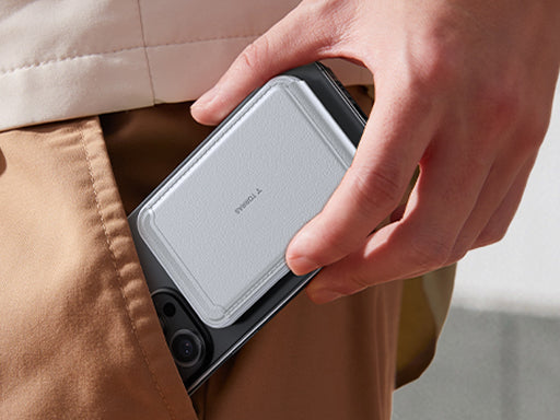 Hand sliding a smartphone with a magnetic card holder into a pants pocket to show slim portability