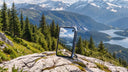 Phone standing on a rocky ledge overlooking mountains and a lake