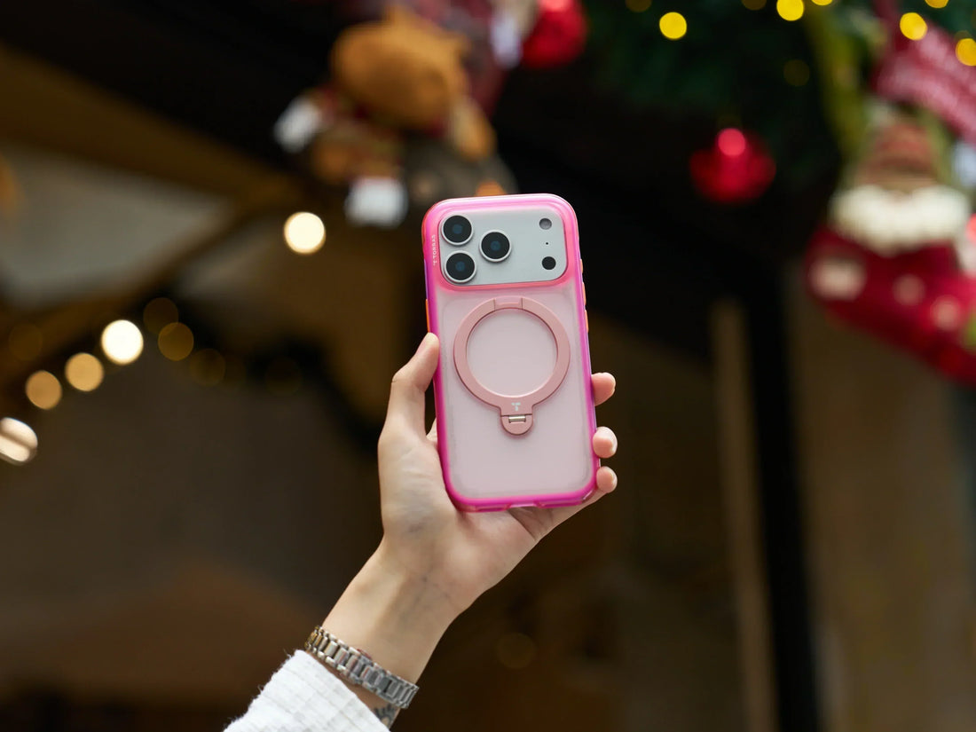 Airbag phone case cover image showing a hand holding a pink ring stand phone case in front of holiday lights