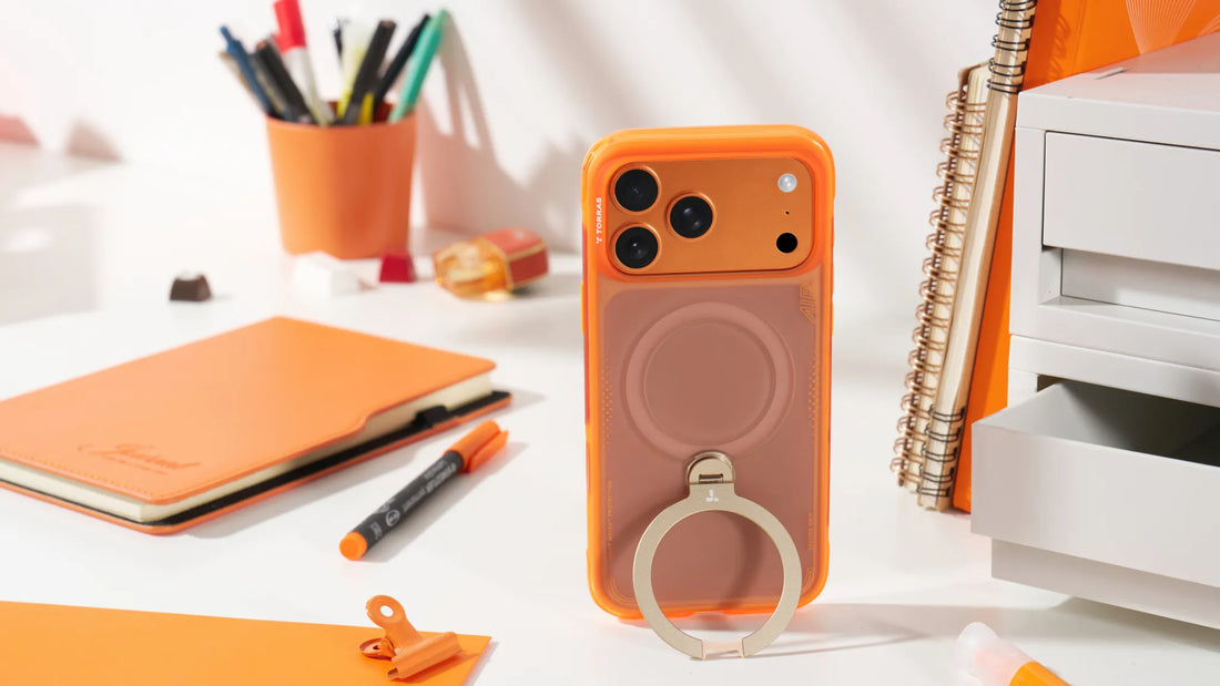 Orange airbag phone case with ring stand displayed on a bright desk with orange stationery and office supplies