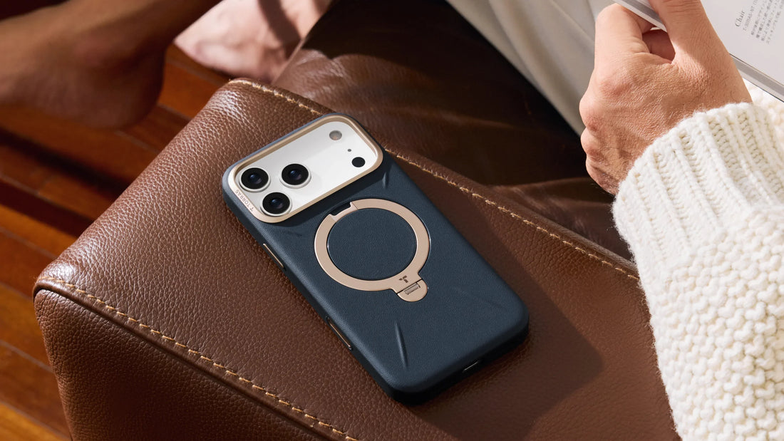 Dark blue TORRAS phone case with a circular ring stand resting on a brown leather armchair