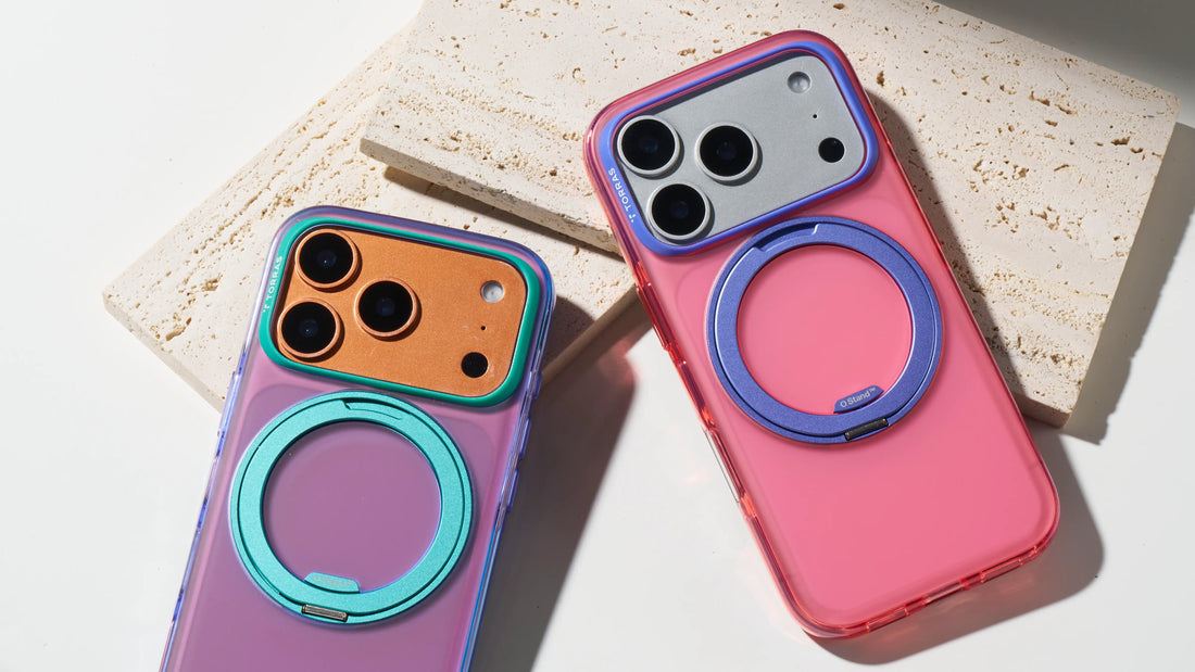 Pink and purple TORRAS phone cases with circular ring stands displayed on textured stone blocks