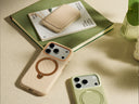 Two phone cases with circular ring stands placed beside books on a softly lit table