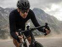 Cyclist using a rugged phone case mounted on bike handlebars during a mountain ride