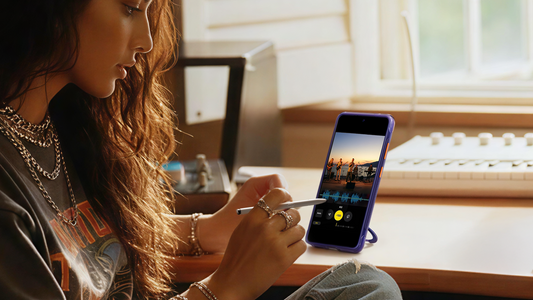 Woman editing video with S Pen on purple S25 Ultra stand case in studio