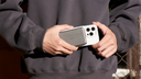 Person holding a white phone case with a magnetic power bank attached