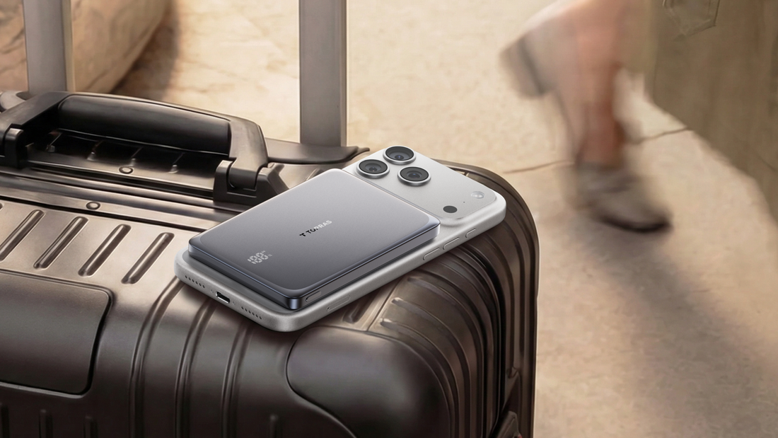 Compact magnetic power bank charging a smartphone on top of a suitcase at an airport