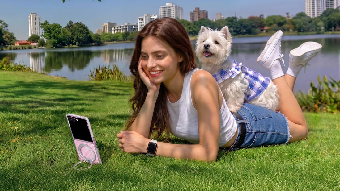 Woman relaxing with a small dog beside a pink foldable phone supported by its ring stand