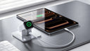 Apple Watch charging on a TORRAS stand beside a tablet connected by cable on a desk