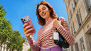 Woman charging her phone on the go with a compact TORRAS portable charging kit clipped to her bag
