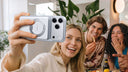 Group of friends taking selfie with iPhone attached to MagSafe portable power bank at dinner