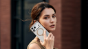 Woman holding a smartphone in a clear case with a circular metal stand