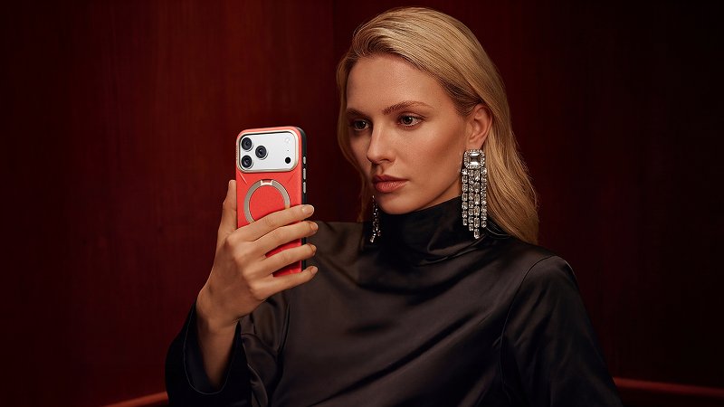 Woman holding a smartphone in a red textured case with a circular metal stand