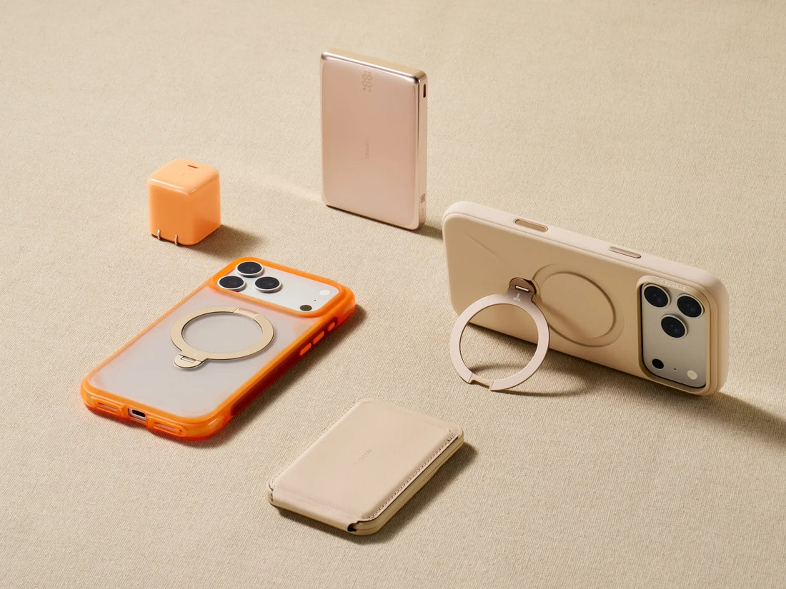 Smartphones in beige and orange cases with circular ring stands, plus a power bank and charging cube.
