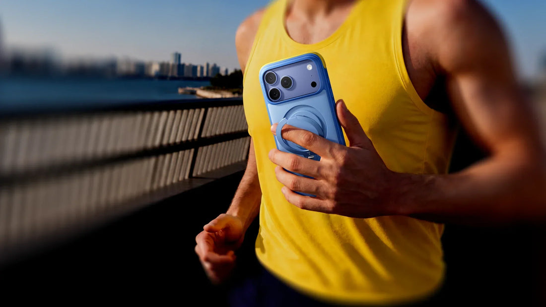 Runner in a yellow tank top carrying an iPhone in a blue case outdoors