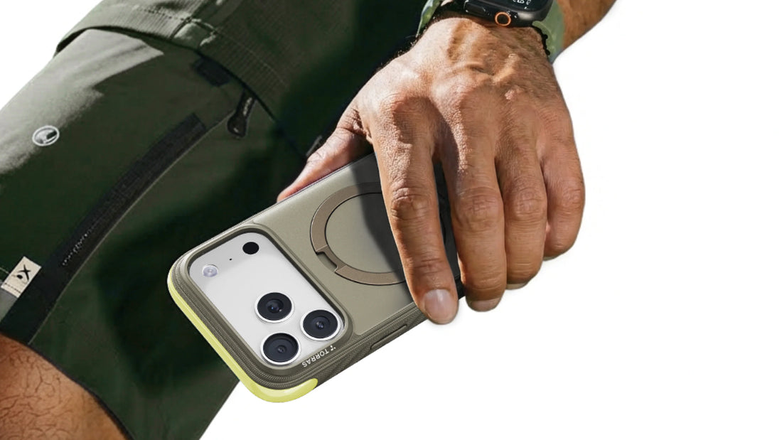 Hand holding an iPhone in a rugged green and yellow case during outdoor activity, showing daily protection for active routines.