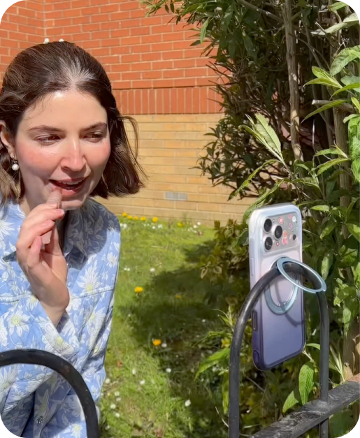 Woman in a garden with a phone on a TORRAS lanyard