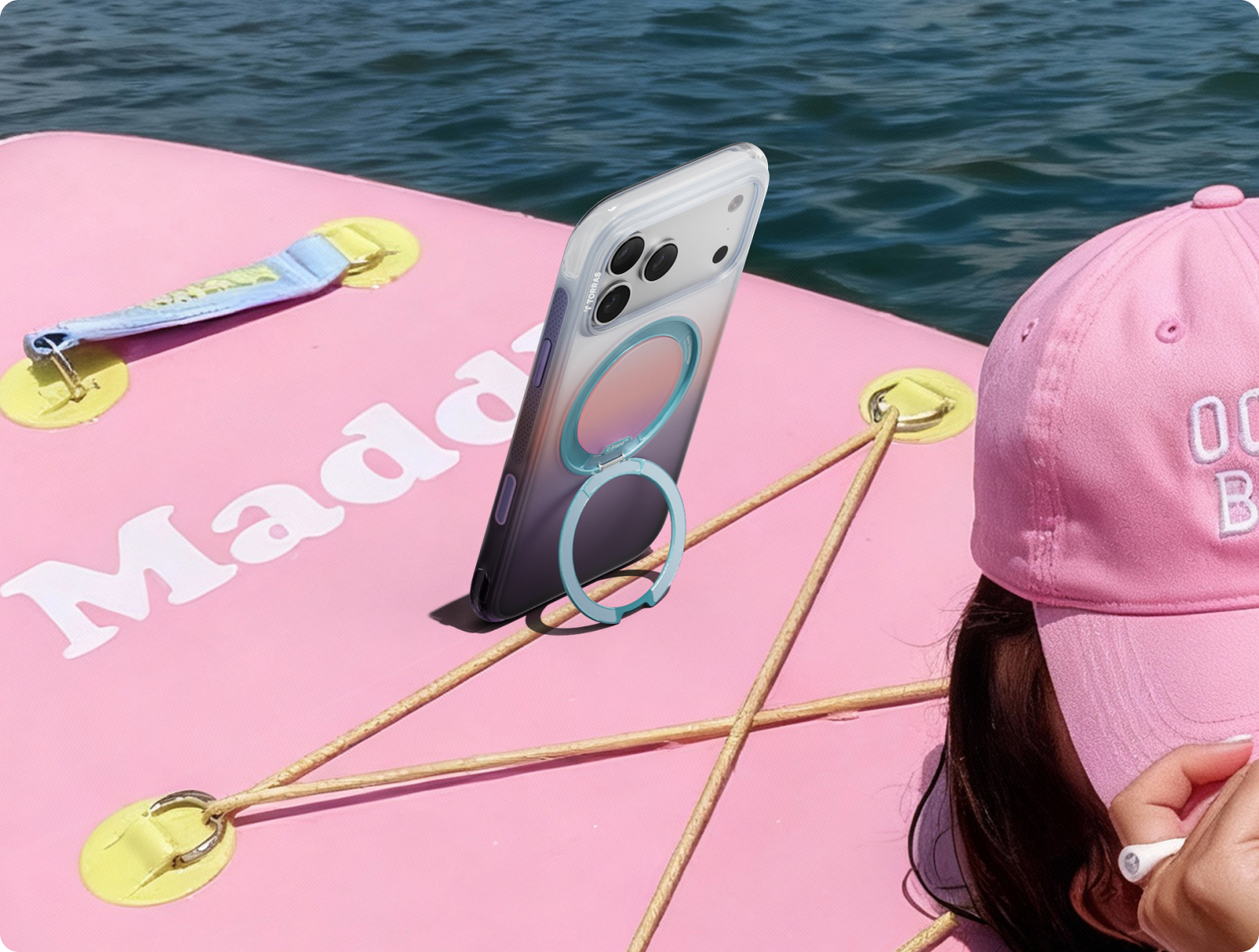 Phone standing on a pool float by its TORRAS ring stand
