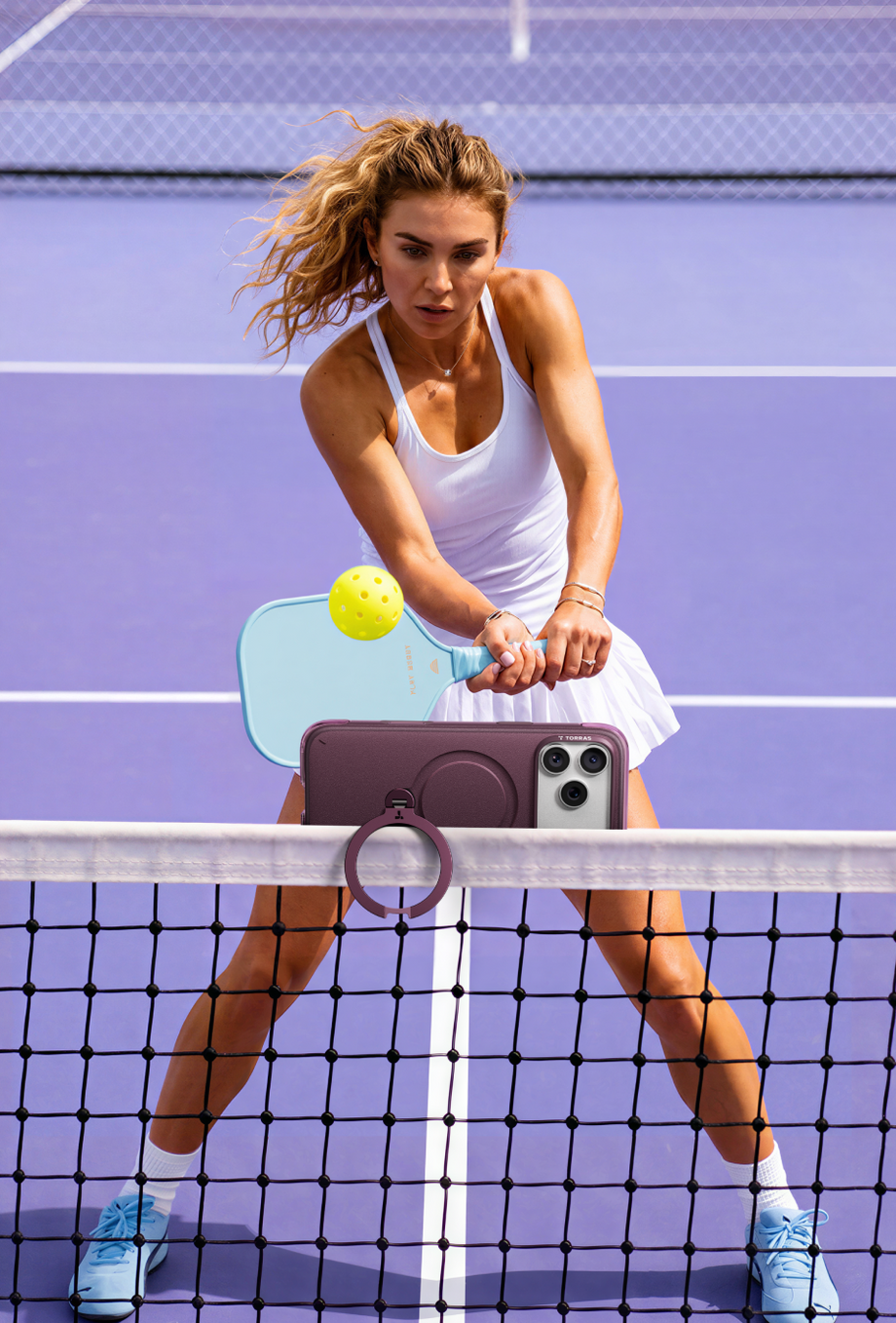 Pickleball player with a phone in a TORRAS ring case on the net