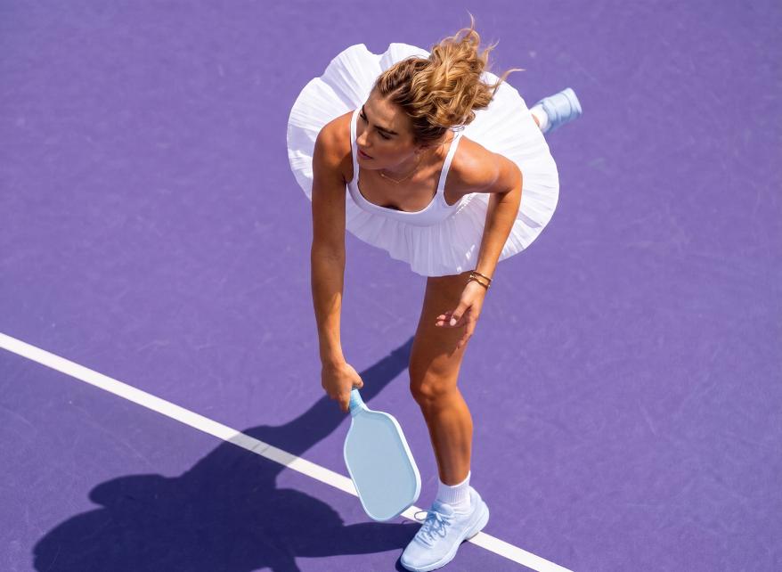 Overhead view of a pickleball player serving on court