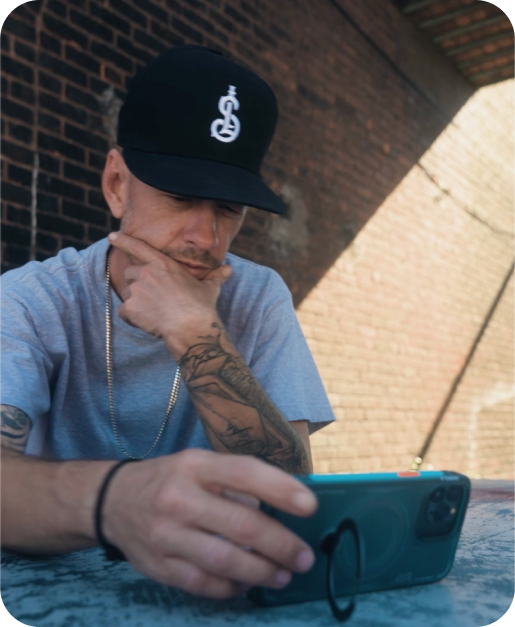 Man using a phone in a teal TORRAS case outdoors