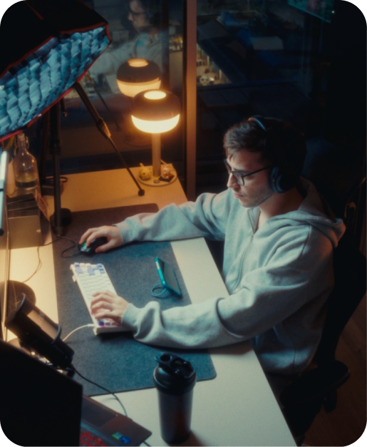 Man working at a desk at night with a phone nearby
