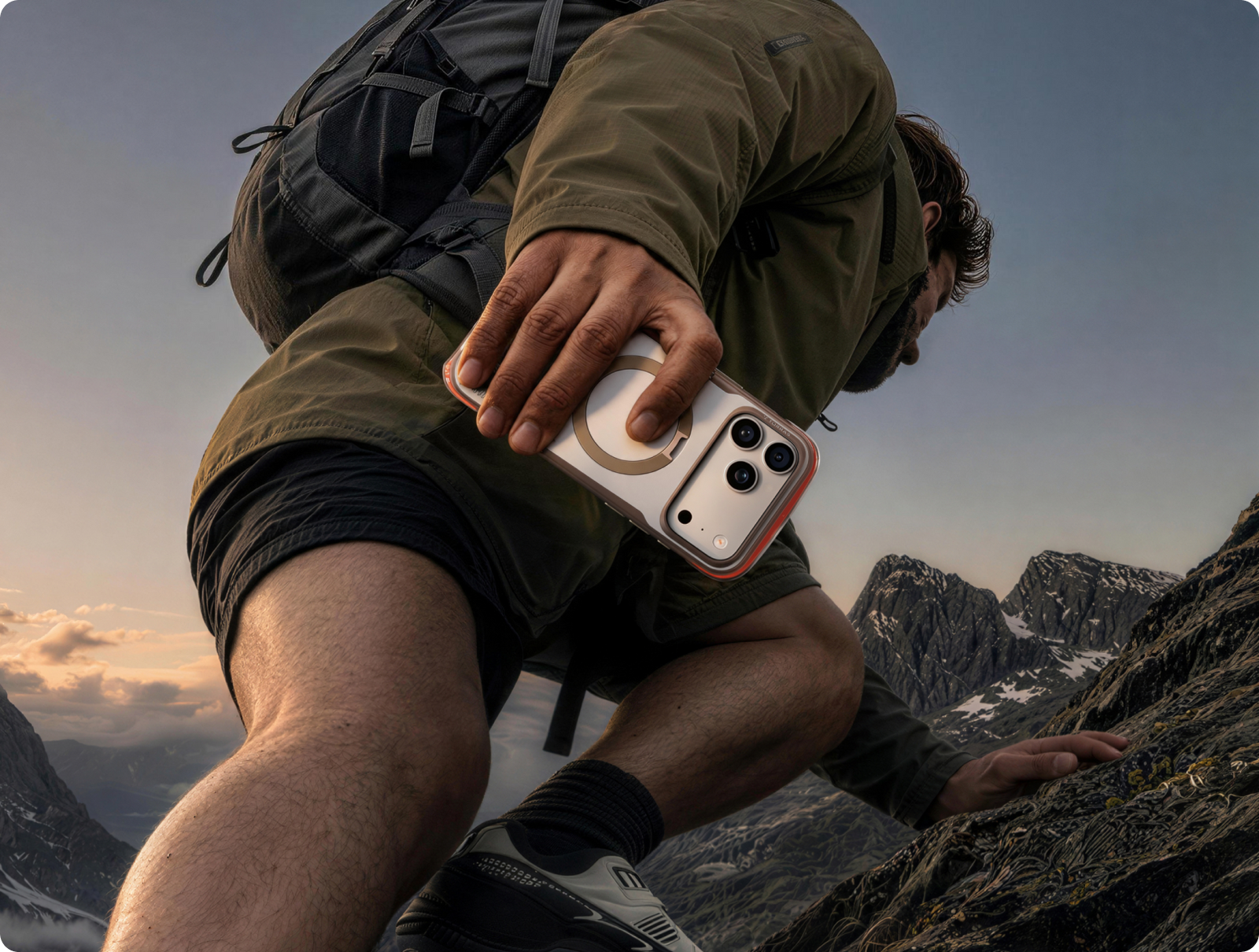 Hiker reaching for a phone in a TORRAS case on a cliff