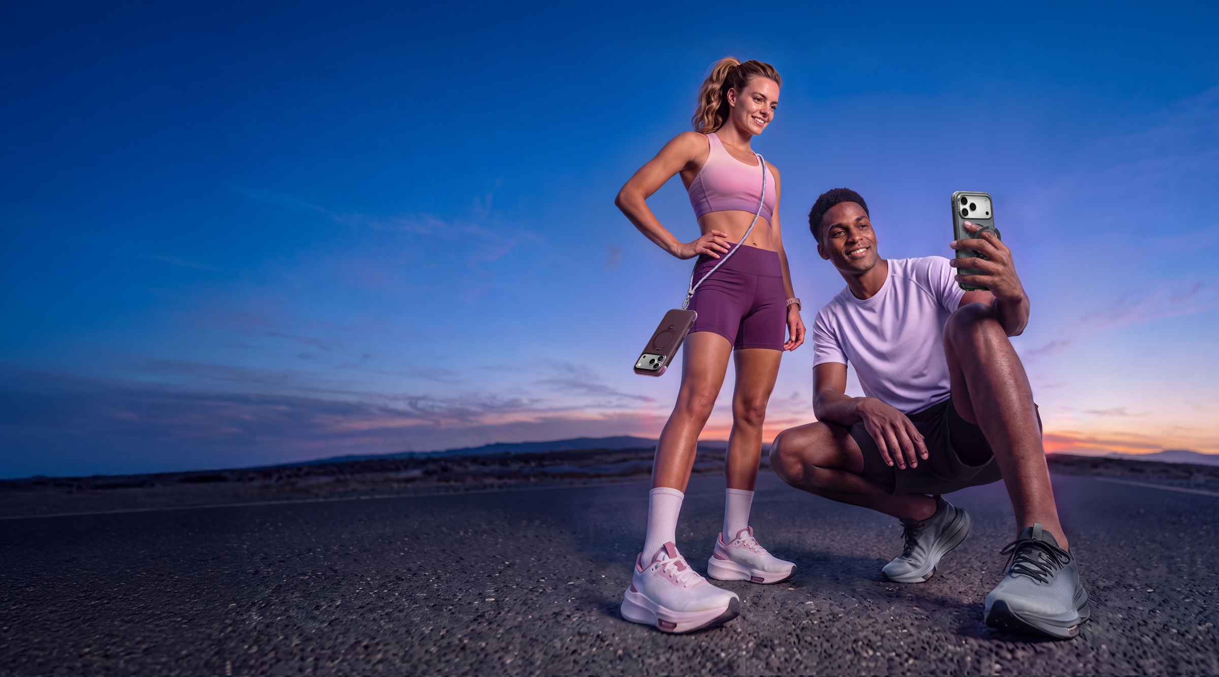 Two athletes outdoors at dusk with a phone in a TORRAS case