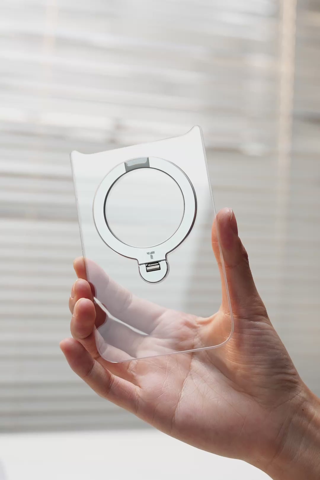 Hand holding a clear TORRAS magnetic ring stand